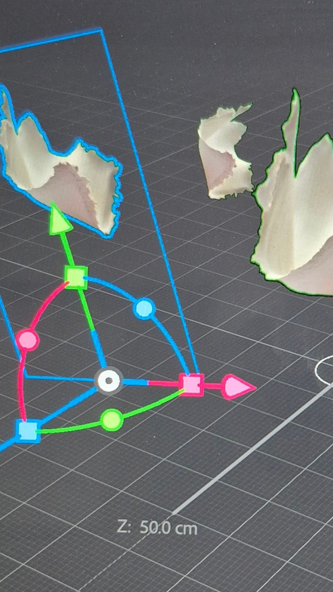 Close-up of a 3D modelling software screen showing abstract, jagged shapes with a colourful XYZ axis manipulator. The scene appears technical and creative.